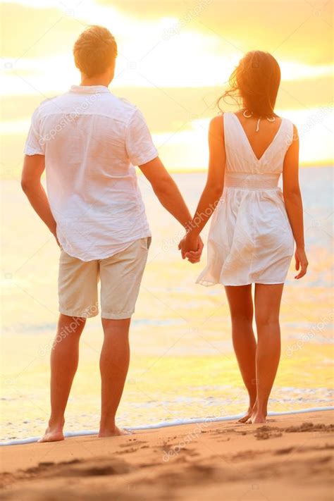 Young Couple Holding Hands At Beach Sunset Stock Photo By ©maridav 25234833