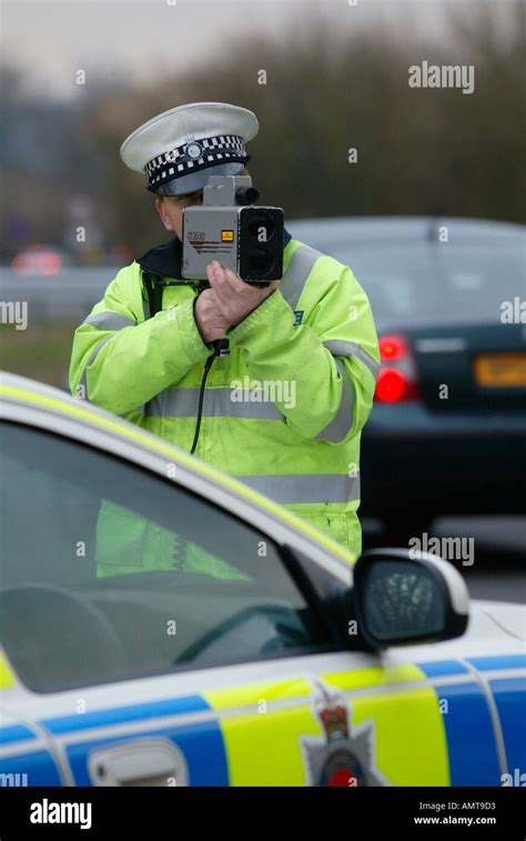 British Traffic Police Officer Monitors The Speed Of Road Traffic Using