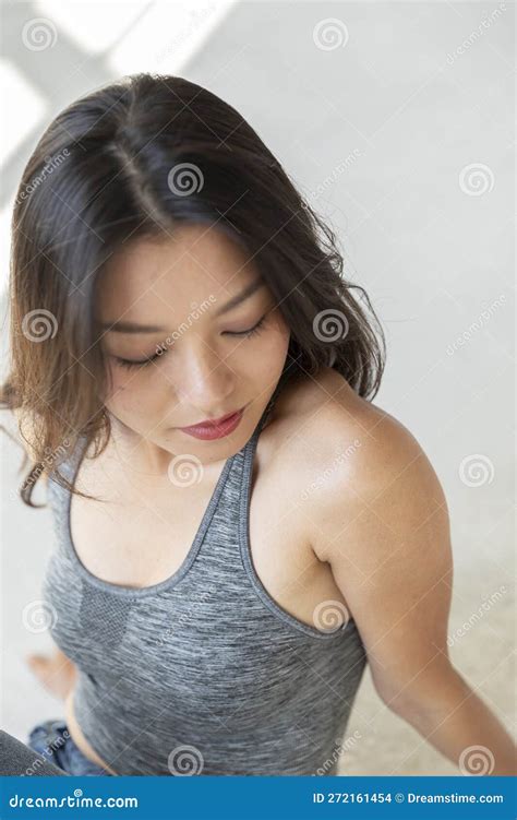 Portrait Of Beautiful Asian Girl Sitting On The Floor She Is Wearing A Sports Top And Looking