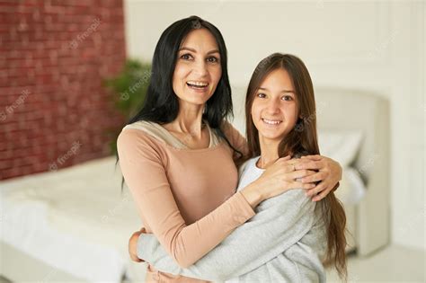 Premium Photo Loving Latin Mother And Daughter Hugging Each Other Smiling At Camera Looking