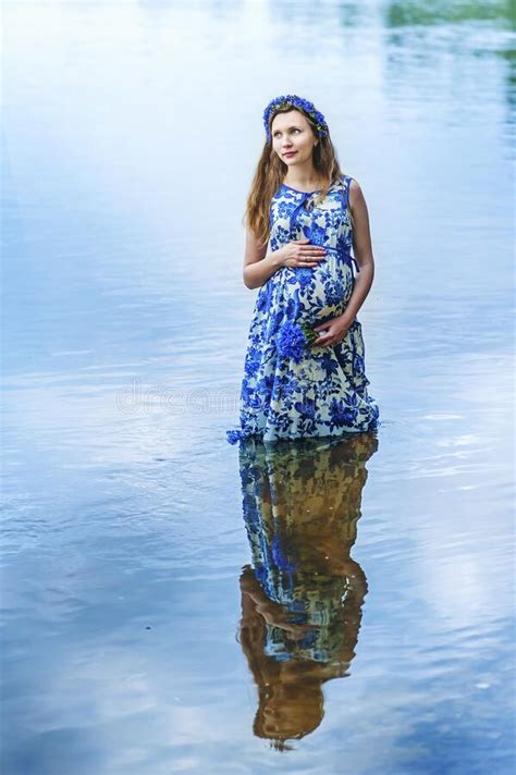 Pregnant Woman Reflection In The Water Stock Photo