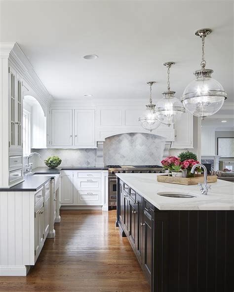 Stainless steel contrasts with a dark island and shades of white in this nate berkus associates kitchen. White Cabinets with Black Island - Transitional - Kitchen ...