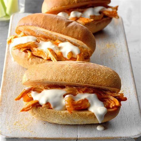 Shredded chicken, barbeque sauce, cheddar cheese squares, and bacon are stacked on top of a flat pretzel. Shredded Buffalo Chicken Sandwiches Recipe | Taste of Home