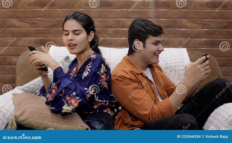 indian brother and sister teasing each other while sitting together on a couch stock footage