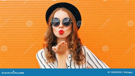 portrait of stylish woman model blowing red lips sending sweet air kiss wearing a black round