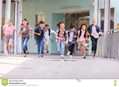 Group Of Elementary School Kids Running In A School Corridor Stock