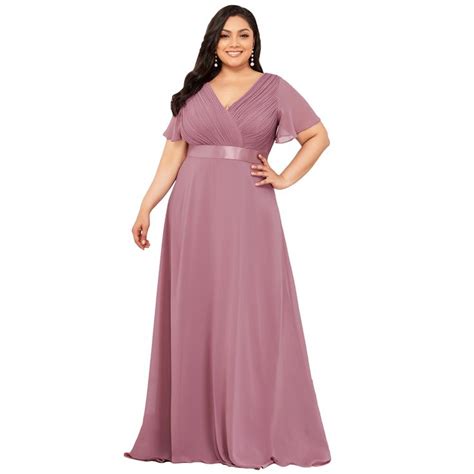 A Woman In A Long Purple Dress With Her Hands On Her Hips Posing For