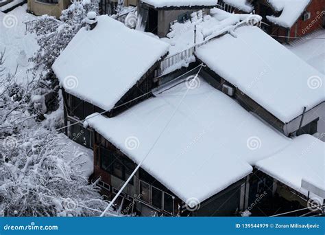 Beautiful Winter View Of Houses And Buildings With Roofs Covered With