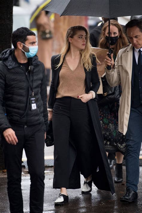 Amber Heard Looks Chic In A Black Trench Coat With Matching Trousers