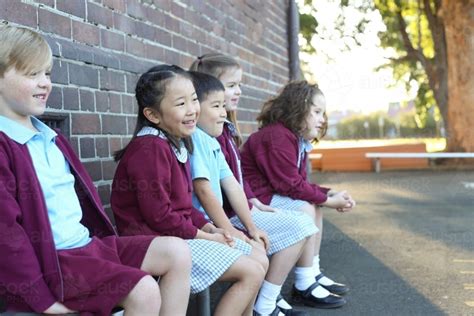 Image Of Happy Children Sitting Outside In The School