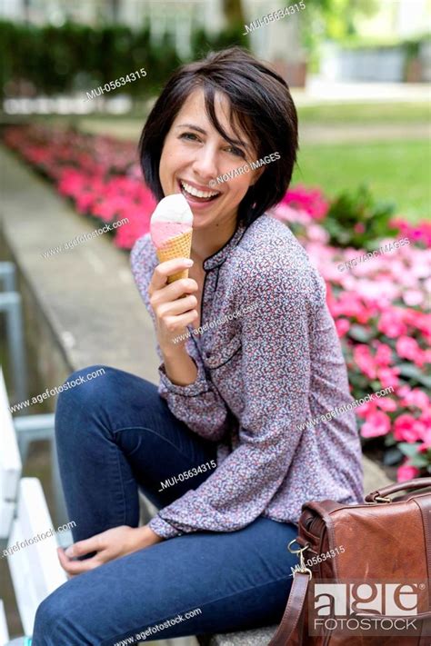 Laughing Woman Sits On Bench And Eats Ice Cream Stock Photo Picture And Royalty Free Image