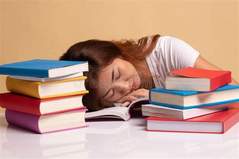 Exhausted Young Asian Woman Sleep With Books On Table Stock Image