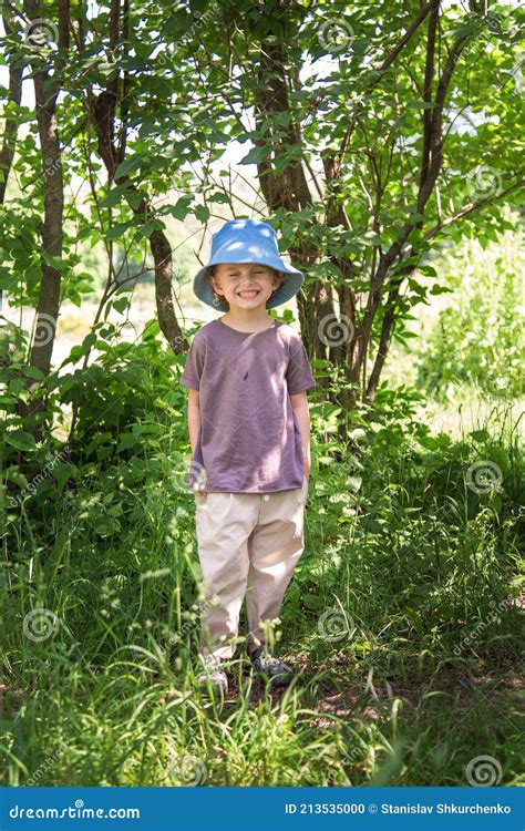 A Little Boy Walks In The Park On A Bright Sunny Day Stock Photo