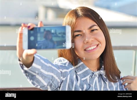 Belle Jeune Fille Et Elle Est Selfies Assis Sur Un Banc Dans La Ville La Journée Ensoleillée