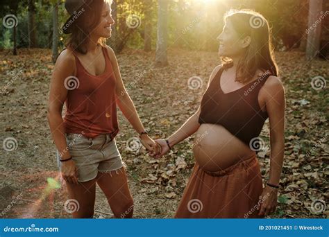 Closeup Of A Pregnant Lesbian Couple Doing A Photoshoot In A Park Stock Image Image Of