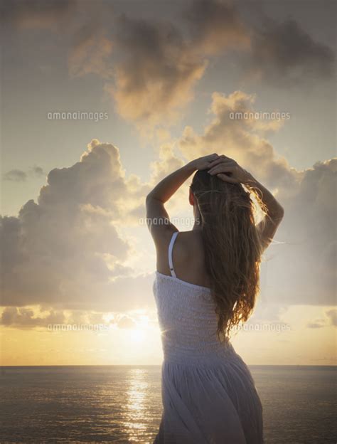 Caucasian Woman Admiring Sunset At Ocean 11018094496 の写真素材・イラスト素材｜アマナイメージズ