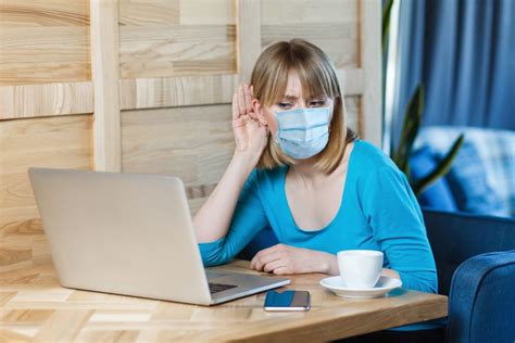 Portrait Of Attentive Young Woman With Surgical Medical Mask Is