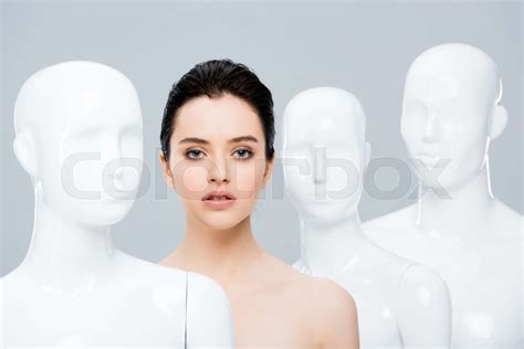 Beautiful Nude Girl Posing Near Mannequins Isolated On Grey Stock