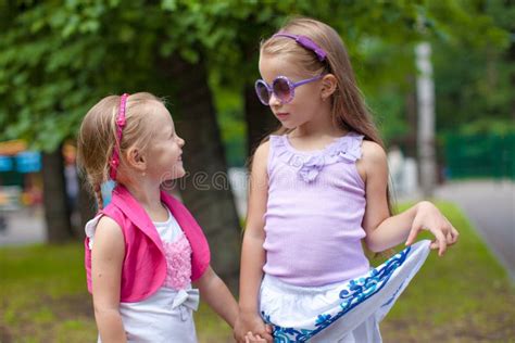 Two Fashion Cute Sisters Go Hand In Hand In The Stock Photo Image Of