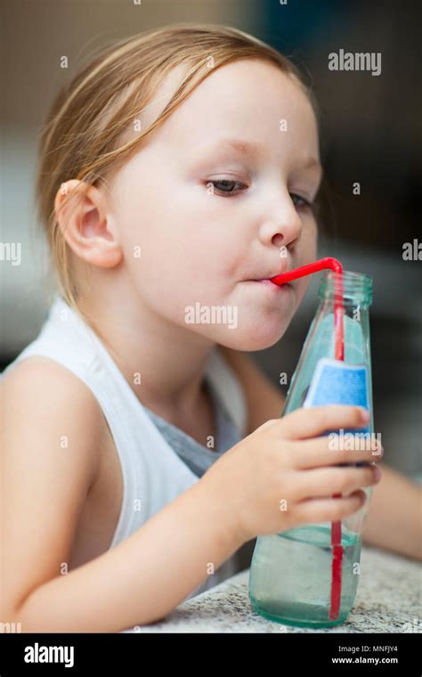 Adorable Little Girl Drinking Water From A Bottle Using A Straw Stock