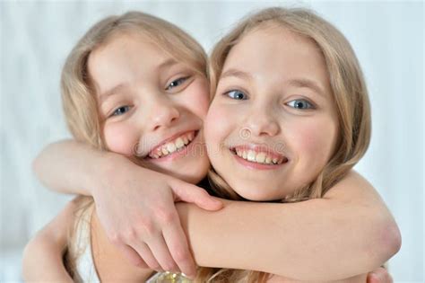 Close Up Portrait Of Cute Twin Sisters Hugging Stock Photo Image Of