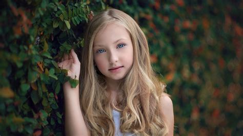 Ash Eyes Blonde Cute Little Girl Is Standing Near Plant Wearing White