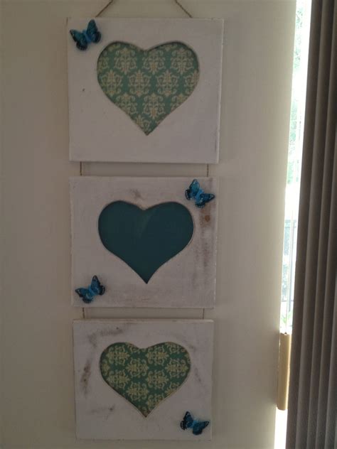 Three Heart Shaped Pictures Hanging On The Wall Next To A Window With