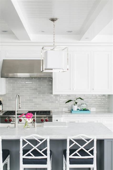 White and gray kitchen features a light gray paneled vent hood placed over a. Gray Center Island with White Bamboo Counter Stools ...
