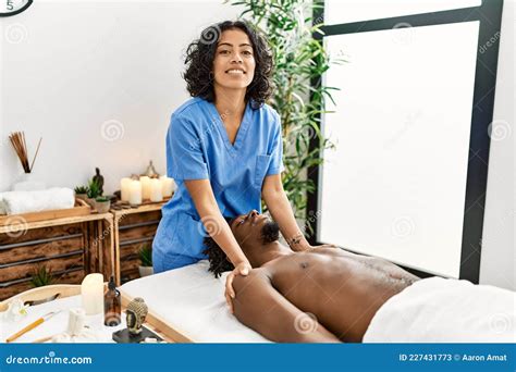Young Physiotherapist Woman Giving Massage To African American Man At The Clinic Stock Image