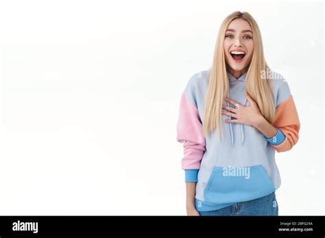 Portrait Of Surprised Blond Girl In Hoodie Look Impressed And Fascinated Touch Chest And Open
