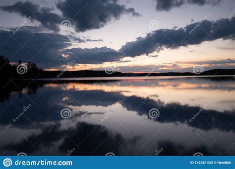 Calm Lake In Sweden At Sunset With Clouds Reflecting In The Water Stock