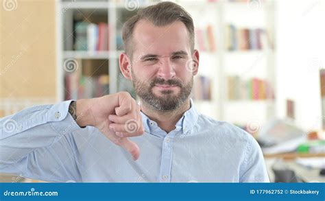 Portrait Of Disappointed Young Man With Thumbs Down Stock Photo Image