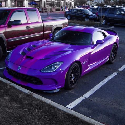 A Purple Sports Car Parked In A Parking Lot Next To Other Cars On The