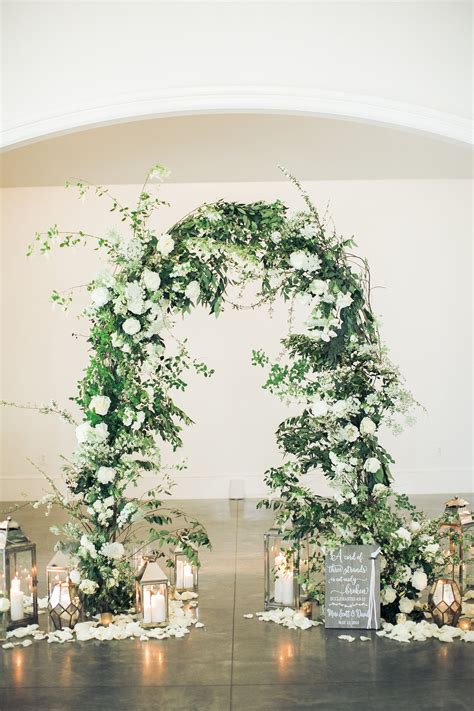 Ceremony Arch With Branches And White Flowers Surrounded By Lanterns