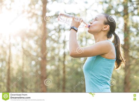 Woman Drinking Water After Work Out Exercising On Sunset Evening Stock