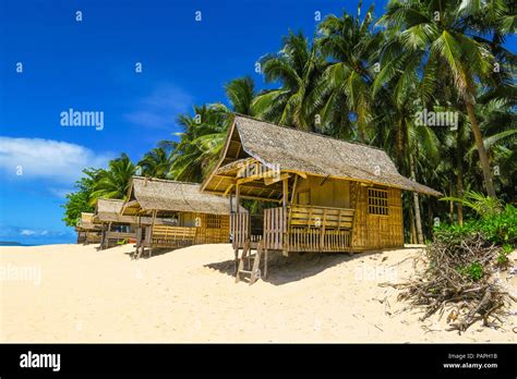 Bamboo Beach Huts In Tropical Paradise With Palm Trees And White Sand
