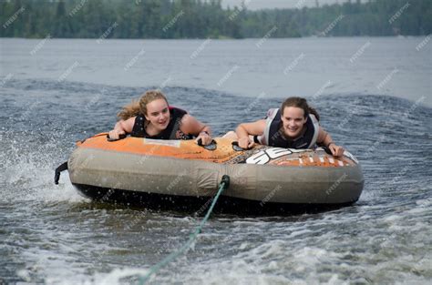 Premium Photo Portrait Of Two Girls Lying On An Inflatable Raft Floating In A Lake Lake Of