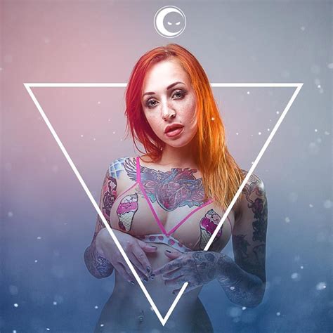 A Woman With Red Hair And Tattoos Standing In Front Of A White Triangle