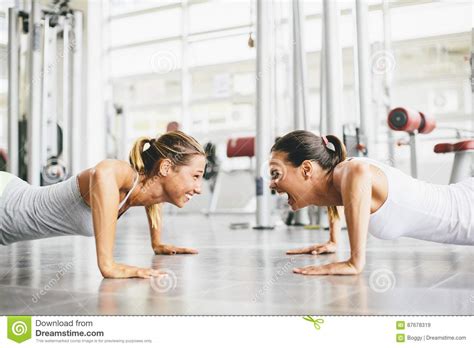 Duas Jovens Mulheres De Sorriso Que Exercitam Em Um Gym Imagem De Stock Imagem De Esporte