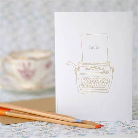 Two Pencils Sitting Next To A Card With An Image Of A Typewriter On It