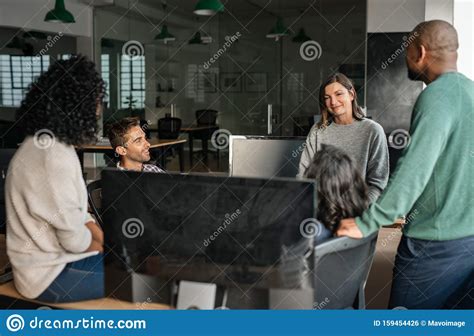 Diverse Designers Discussing Work Together In An Office Stock Photo
