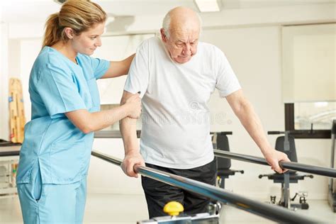 Il Fisioterapista Aiuta Gli Anziani A Seguire Un Corso Di Formazione Immagine Stock Immagine