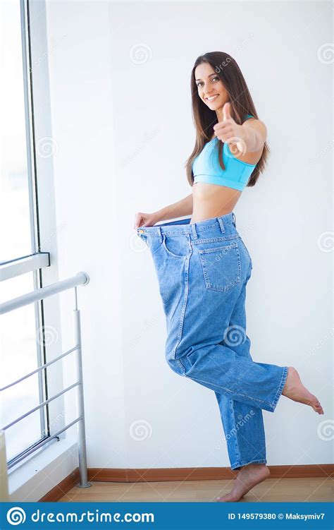 R Gime La Femme Lui Montre La Perte De Poids Et Utiliser Ses Vieux Jeans Photo Stock Image Du
