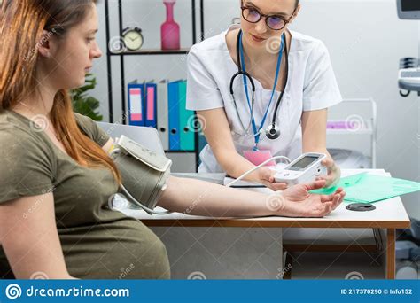 eine dame arzt überprüft das ergebnis nach der prüfung einer schwangeren patientin mit einem