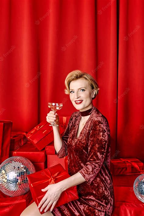 Premium Photo Mature Stylish Elegant Woman With Glass Of Sparkling Wine With Present On Red