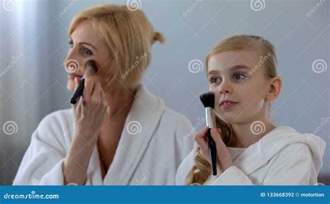 Smiling Grandma And Granddaughter Applying Face Powder Beauty Day At