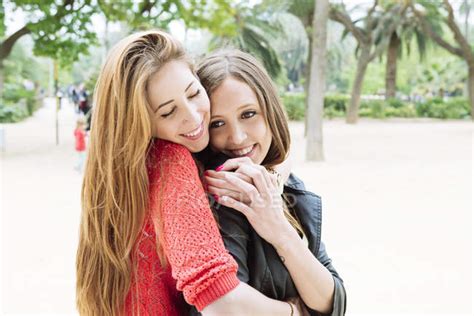 Two Female Friends Hugging In A Park — Friendship Holding Hands