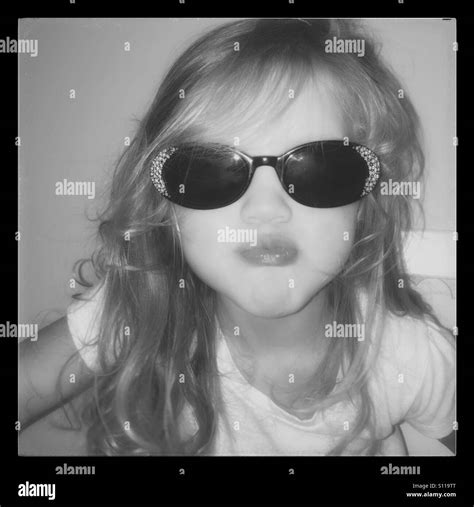 Little Girl Wearing Black Sunglasses With Rhinestones Making A Face