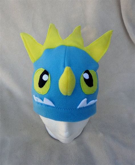a blue and yellow dragon hat with big eyes