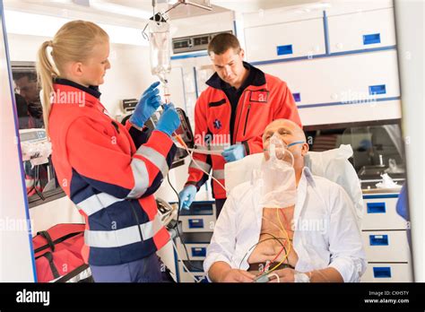 Paramedic Putting Oxygen Mask On Patient Ambulance Sick Emergency Stock